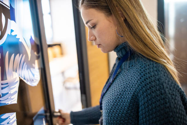 Caucasian female staff using ID enter key to open the door at the building